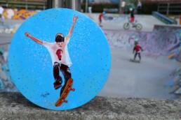 Skater painting on vinyl record at skate park, by Claudio Bindella